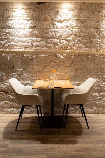 Table pour deux devant le mur de pierre, dîner du dimanche soir chez Astral à Lyon